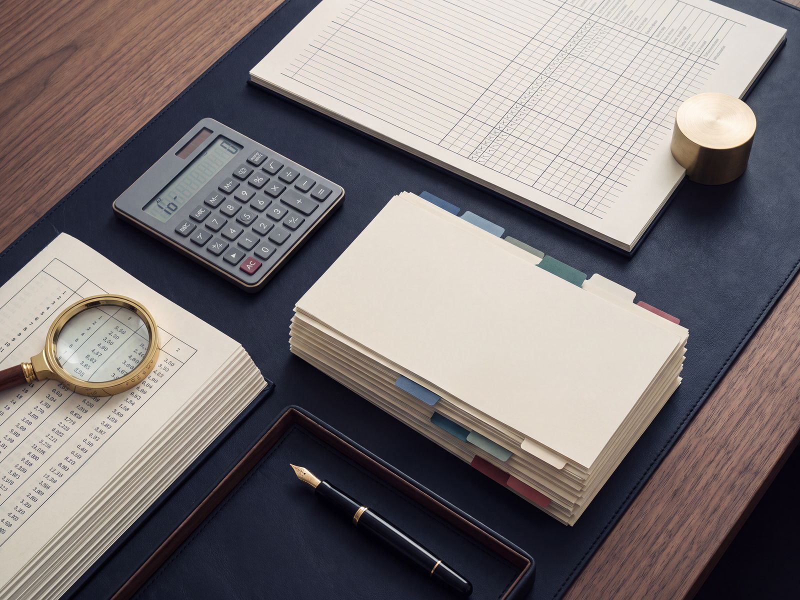 Overhead view of internal control working papers, checklists and a calculator on a desk.